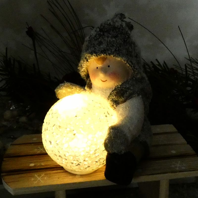 Dekorační postavička zimního dítěte- sedící kluk s LED koulí, 12 cm