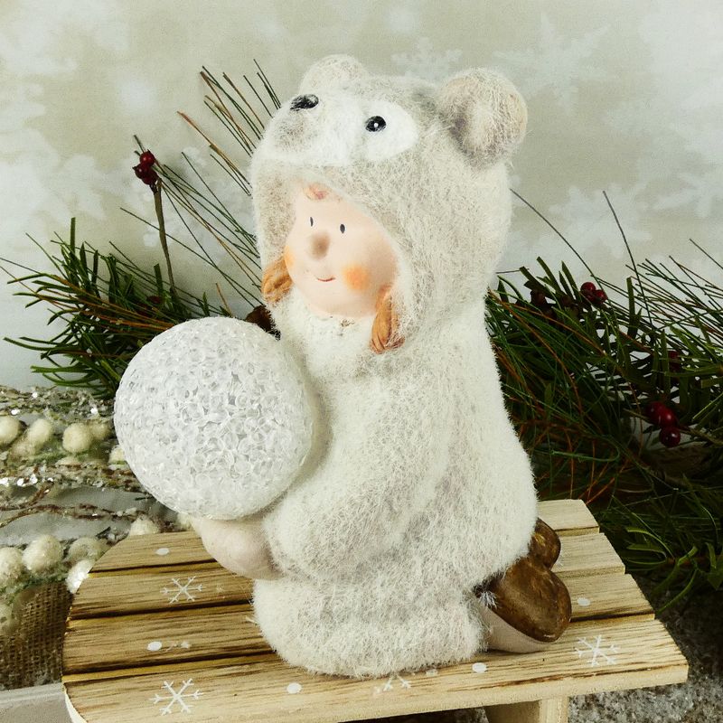 Figurka zimního dítěte- klečící holka v medvědím oblečku s LED koulí, 16 cm