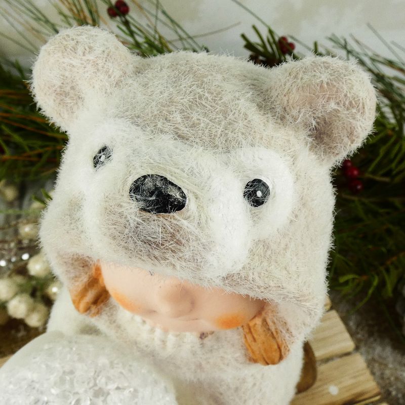 Figurka zimního dítěte- klečící holka v medvědím oblečku s LED koulí, 16 cm